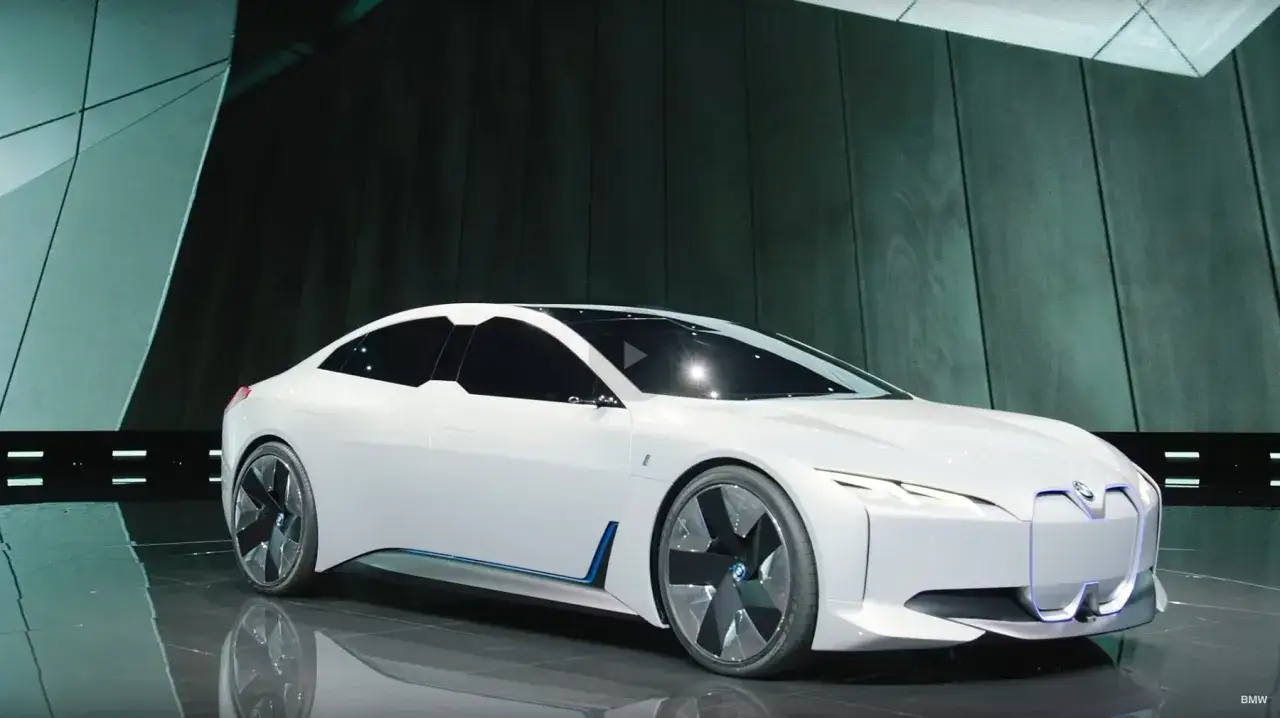 Białe BMW i4 na scenie, futurystyczny design. Poznaj jego dane techniczne i możliwości.