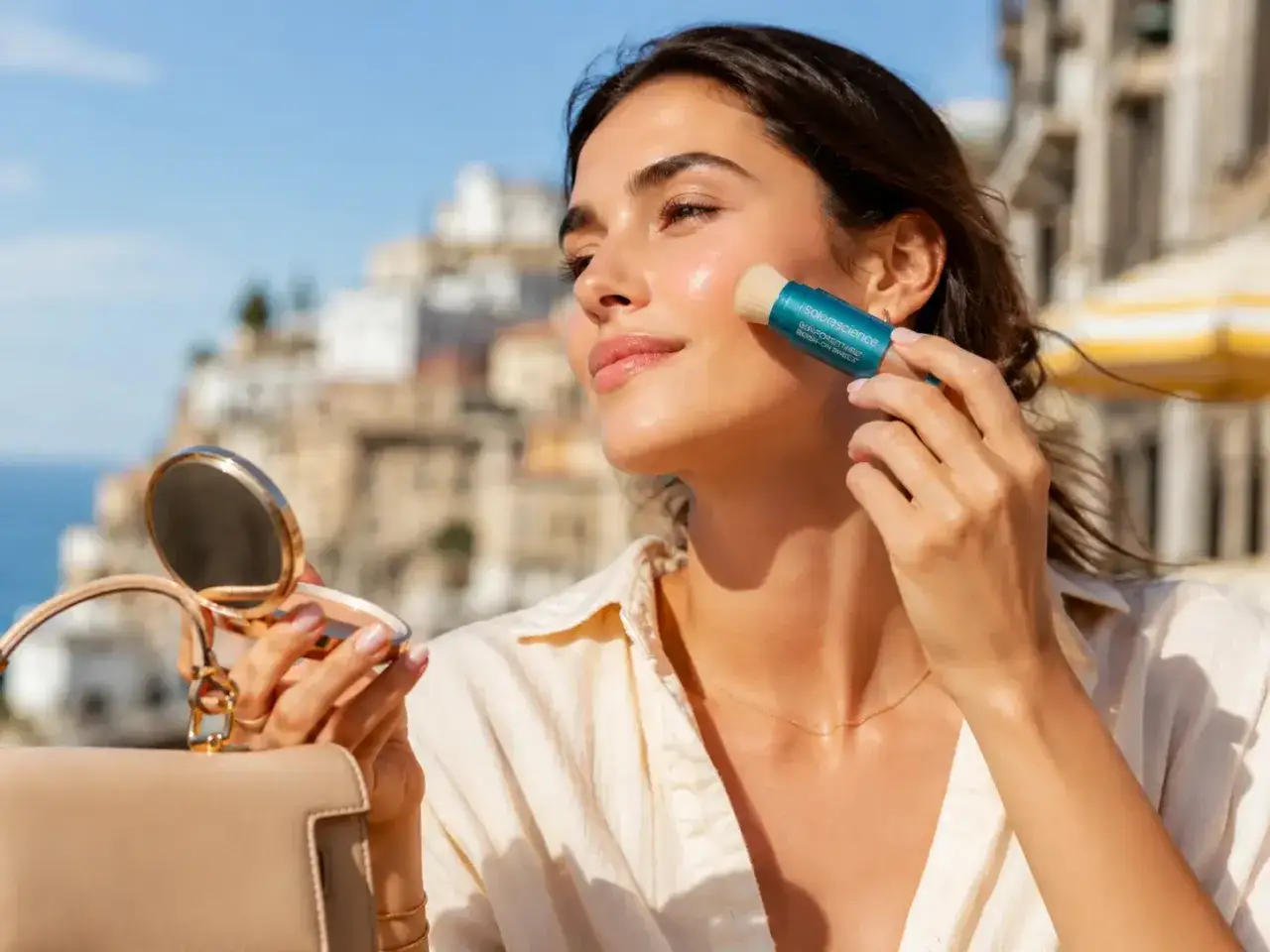 Donna applica la cipria con un pennello integrato, mostrando come mettere la cipria senza pennello per un ritocco veloce.