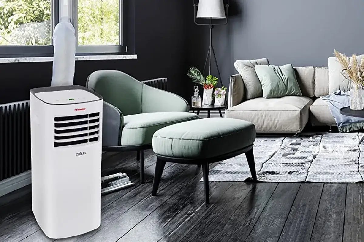 Aire acondicionado port&aacute;til, un split peque&ntilde;o ideal para mantener fresco tu sal&oacute;n moderno con sof&aacute; y sill&oacute;n.