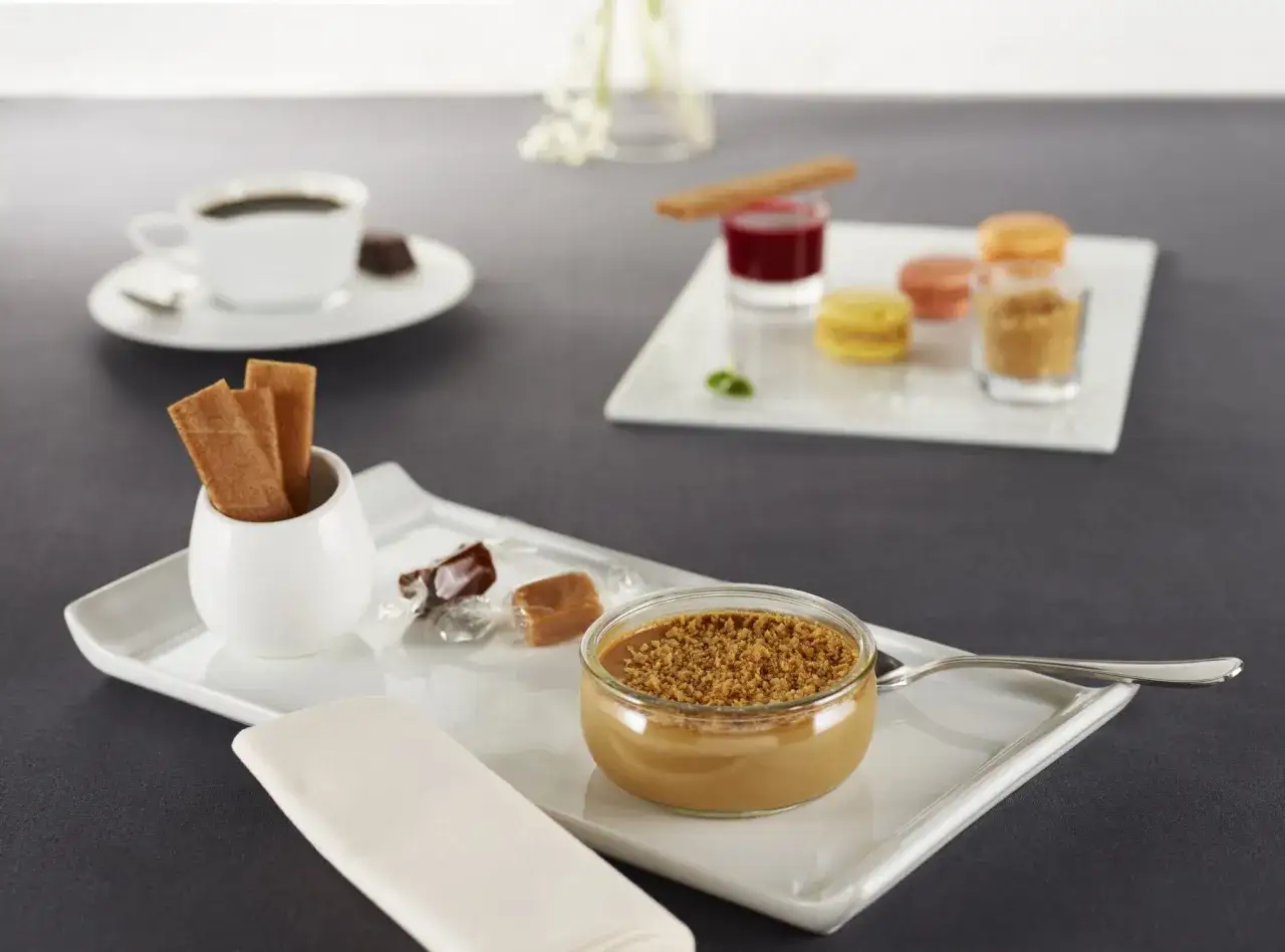 Un café gourmand avec verrine caramel, macarons, et biscuits. Idéal pour des recettes de mignardises pour café gourmand.