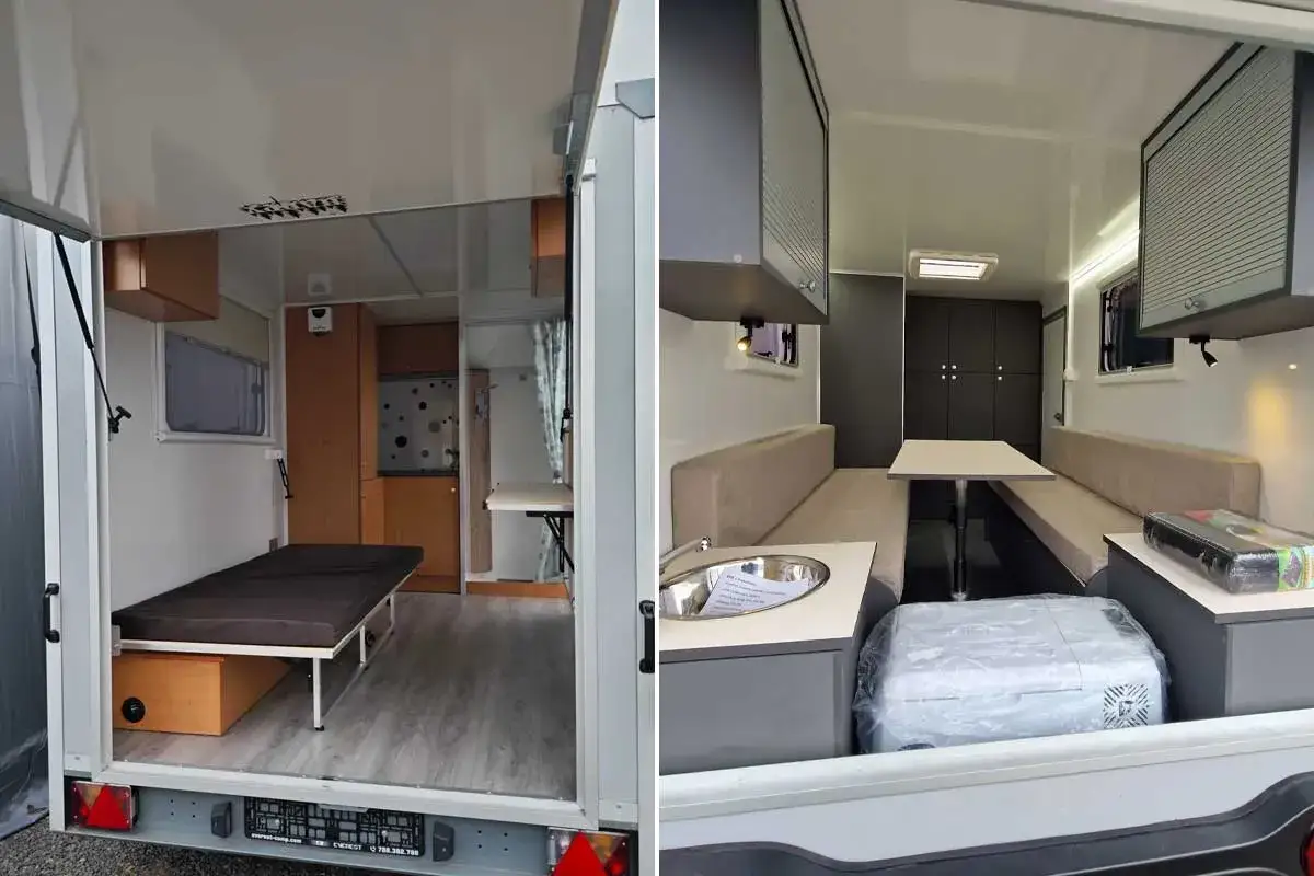 Intérieur d'une caravane goutte d'eau avec lit, coin repas et cuisine.