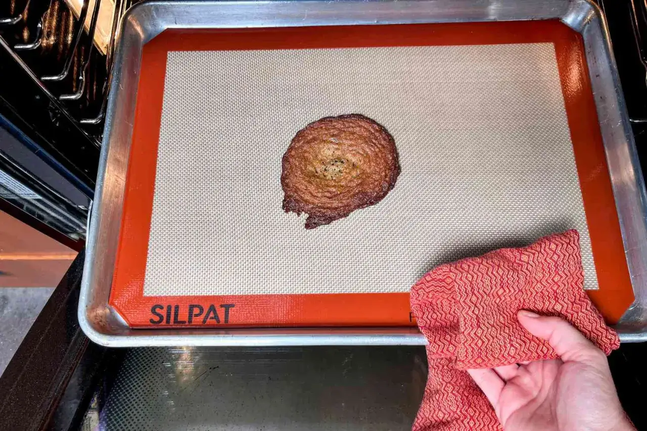 Una galleta dorada sobre un silpat, que es una alfombrilla de silicona antiadherente para hornear.