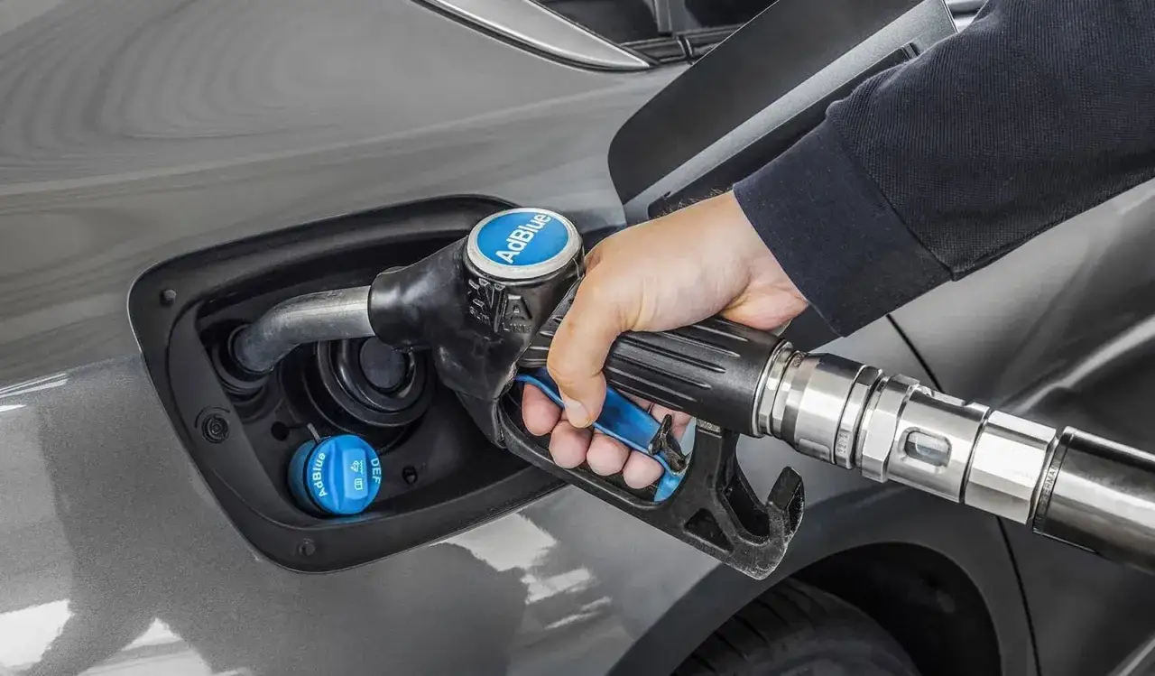 Mano repostando AdBlue en un coche. Averigua cuanto AdBlue consume un coche para mantenerlo en marcha.