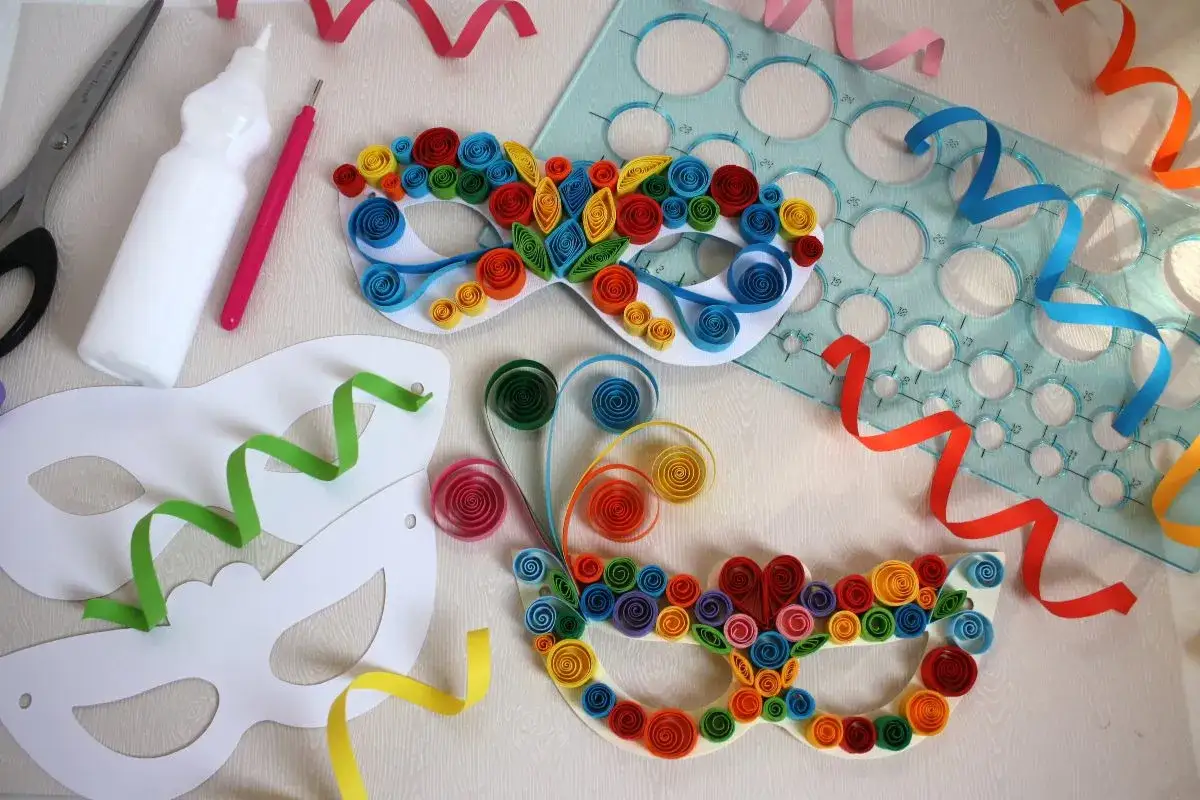 Creazione di una maschera carnevale fai da te con carta colorata arrotolata. Forbici, colla e stencil per un'esplosione di creativit&agrave;.