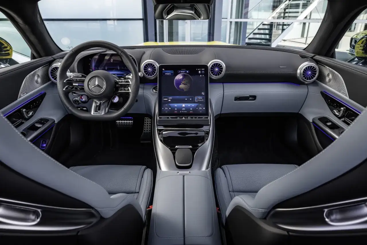 Wnętrze Mercedes-AMG GT 43 z cyfrowymi zegarami, ekranem dotykowym i sportowymi fotelami.