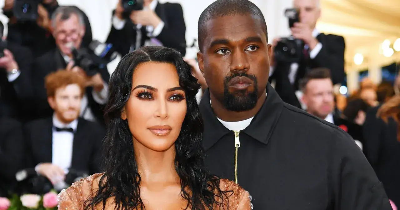 Kim Kardashian z mężem Kanye Westem na czerwonym dywanie, otoczeni przez fotoreporterów.