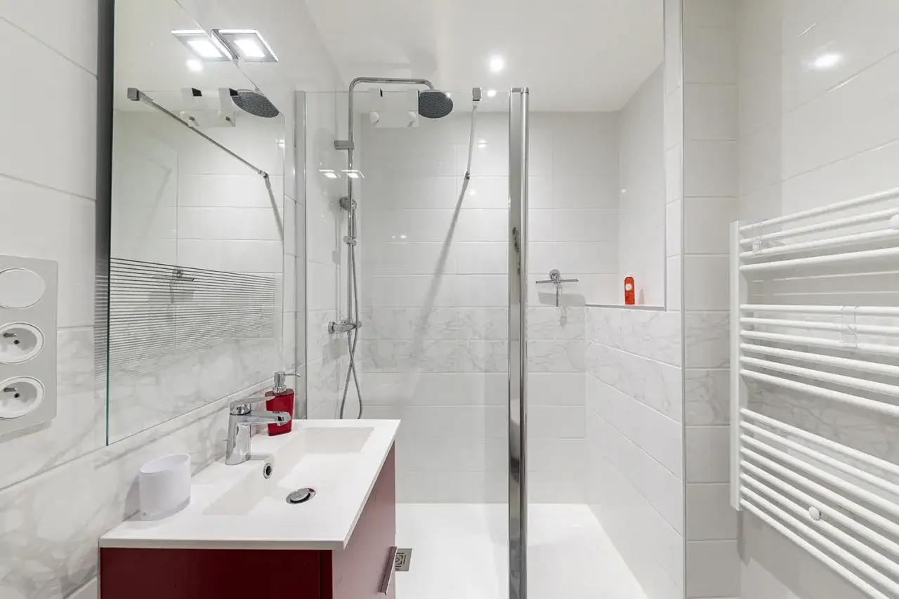 Salle de bain moderne avec douche, lavabo et porte-serviettes chauffant. Le prix de cette salle de bain est très attractif.