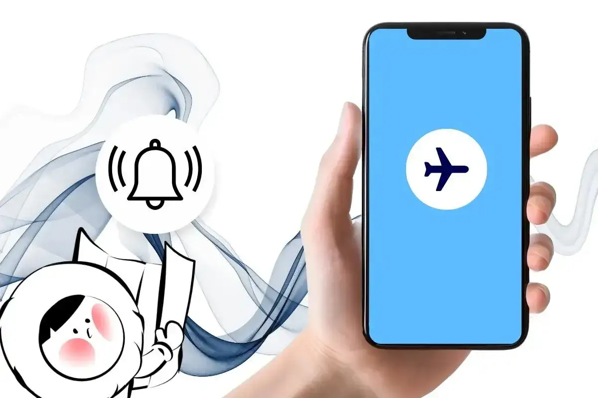 Dłoń trzyma smartfon z ikoną samolotu, obok dzwonek. Czy w trybie samolotowym działa budzik?