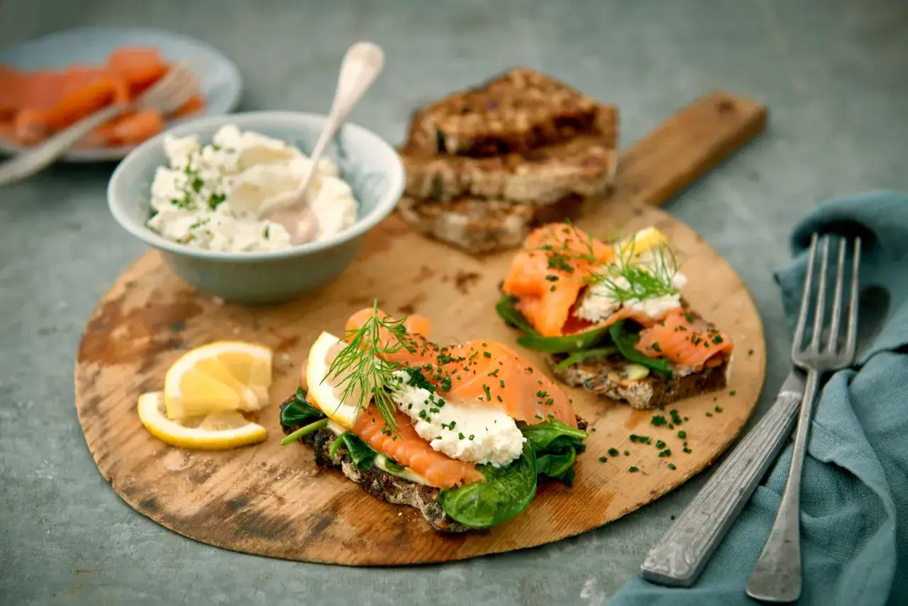 Två läckra gravad lax mackor med färskost, dill och citron på grovt bröd. En härlig svensk delikatess.
