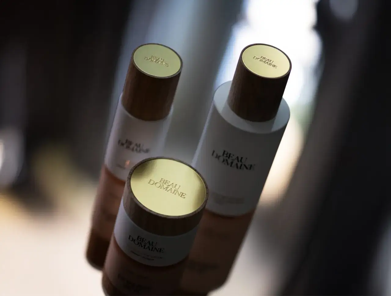Tre flaconi Beau Domaine con tappi dorati e in legno. Ideali per chi ama usare siero senza crema per una routine leggera.