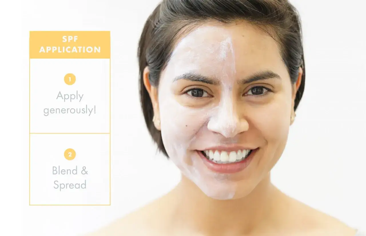 Application de crème solaire : un indice pour le temps. Une femme sourit, le visage à moitié couvert de crème solaire blanche.