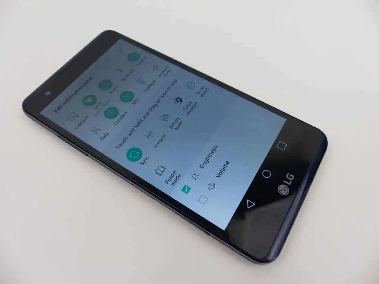 Telefon LG X Power 3 z włączonym panelem powiadomień. Widoczne opcje: Wi-Fi, Lokalizacja, NFC, Jasność, Głośność.