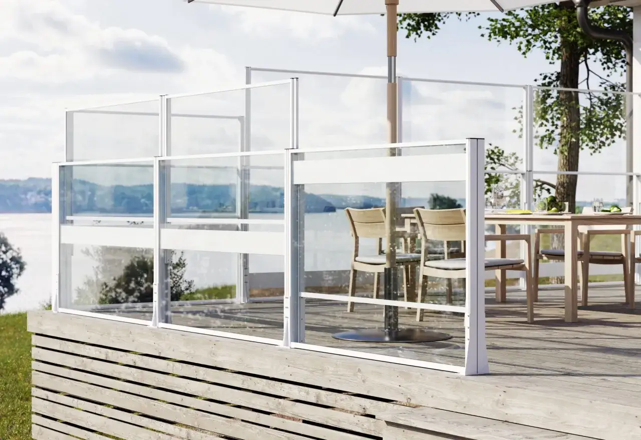 Vindskydd f&ouml;r altanen ger skydd mot vind och skapar en mysig uteplats. Glaspartier med vita ramar.
