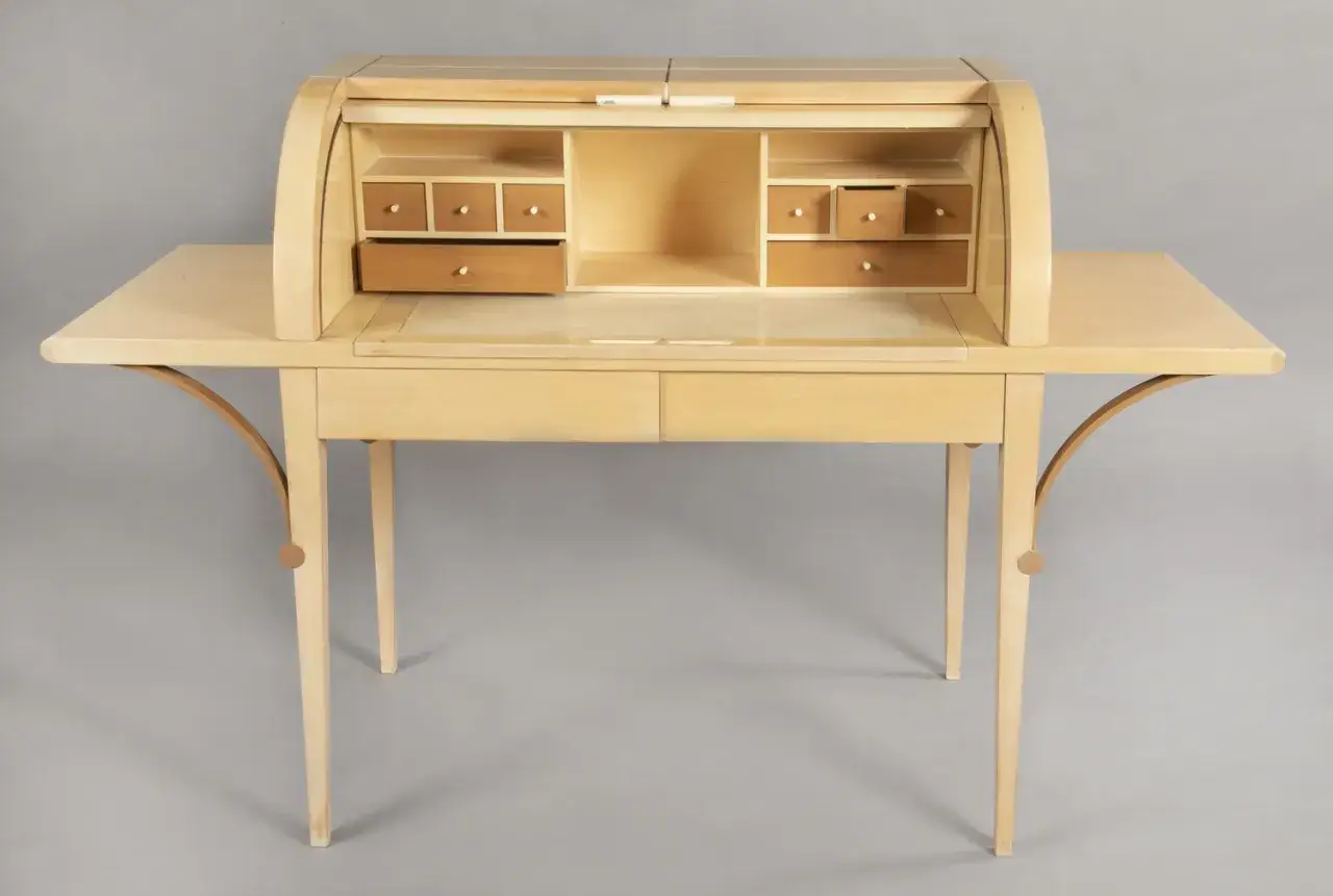 Bureau secr&eacute;taire en bois clair, avec un abattant roulant et de nombreux tiroirs. Un beau meuble de rangement sign&eacute; Hurel Mobilier.