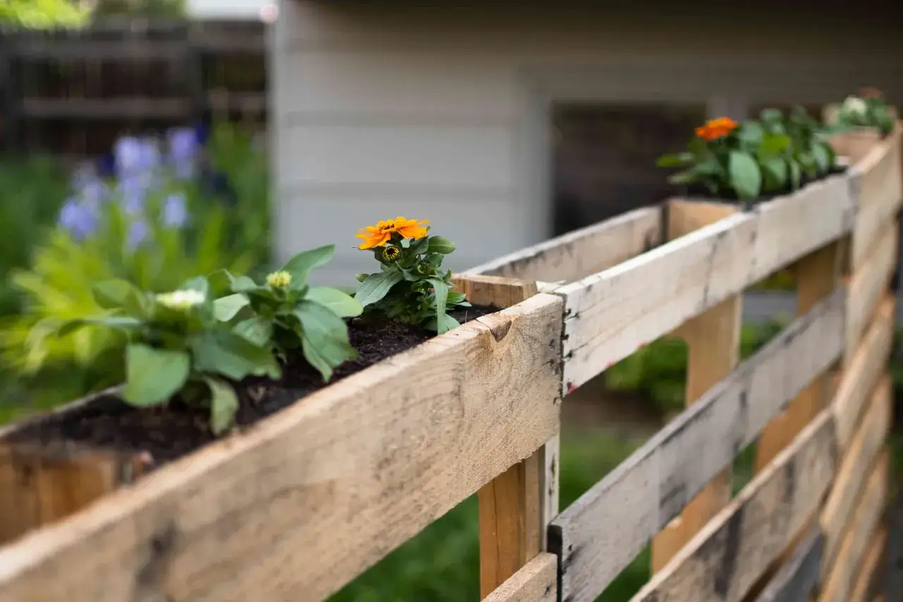 Blumenk&auml;sten aus Paletten: 1001 Ideen Garten gestalten mit wenig Geld. Orange und gr&uuml;ne Bl&uuml;ten schm&uuml;cken die selbstgemachte Gartendeko.
