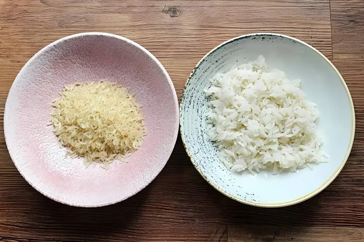 Zwei Schalen Reis: links ungekochter Basmati, rechts gekochter Langkornreis. Der Unterschied ist deutlich sichtbar.