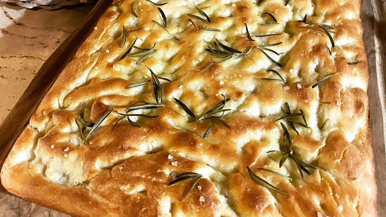Focaccia original con romero fresco y sal marina gruesa, recién horneada y dorada.
