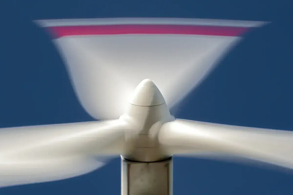 Drehende Rotorblätter eines Windrads vor blauem Himmel. Ein Symbol für saubere energie schweden.
