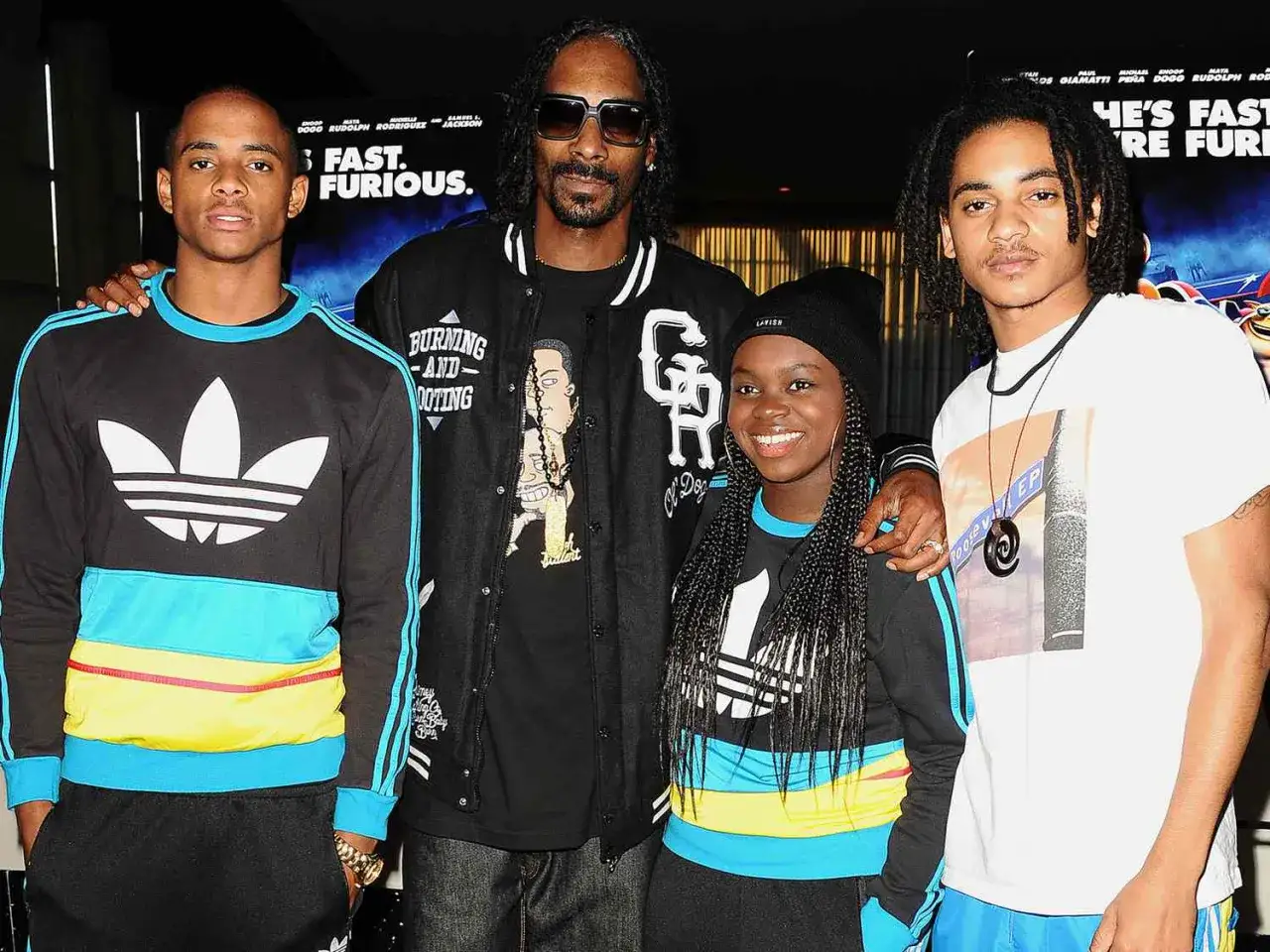 Snoop Dogg z dziećmi, dwoma synami i córką, pozuje do zdjęcia.