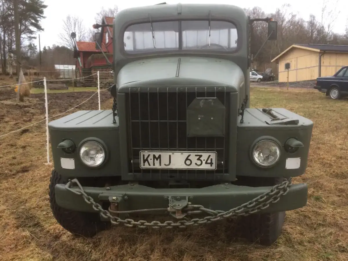 En grön militär Volvo sugga med registreringsskylten KMJ 634 står på en gräsbevuxen äng.