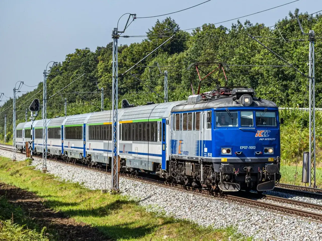 Pociąg PKP Intercity EP07-1002 z Poznania do Zakopanego jedzie po torach.