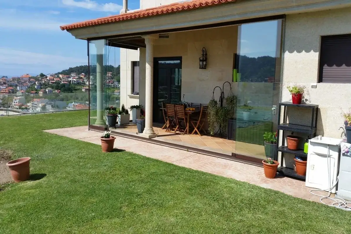 Porches cerrados de obra con vistas panor&aacute;micas. Una mesa y sillas de madera invitan a disfrutar del exterior.