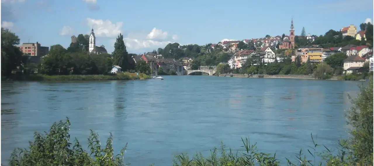 R&iacute;o azul con ciudad en la orilla, iglesias y un puente. Un tramo de la EuroVelo 15, ideal para ciclistas.