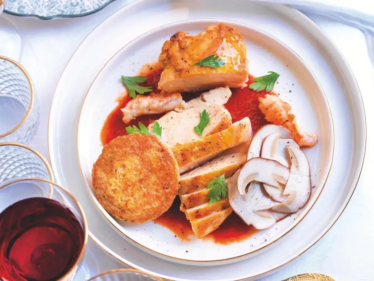 Piatto di pollo alla marengo con salsa rossa, funghi affettati, gamberi e una croccante tortino.