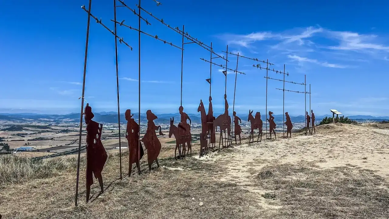 Silhouetten von Pilgern auf einem Hügel, die den Weg nach Santiago de Compostela symbolisieren. Was ist ein Pilger? Jemand, der auf einer spirituellen Reise ist.