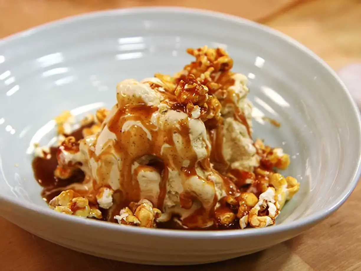 Glass med vaniljglass, toppad med krispig popcorn med kolasås och extra kolasås som rinner ner. En söt och salt dröm!