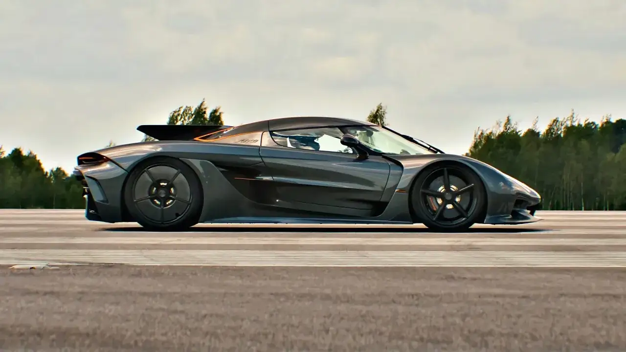 Szary Koenigsegg Jesko na torze, z drzewami w tle.