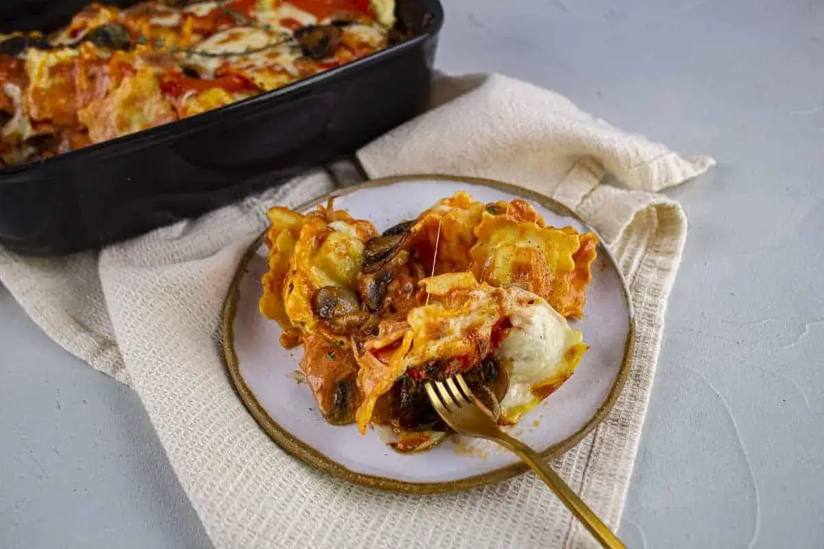 Raviolis gratinés aux champignons et sauce au comté, un plat réconfortant prêt à être dégusté.