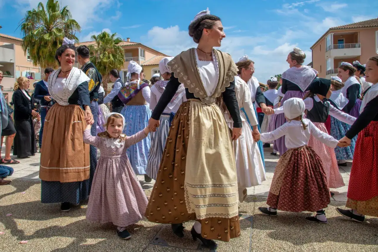 Un groupe danse en tenue traditionnelle française, hommes et femmes, lors d'une fête folklorique.