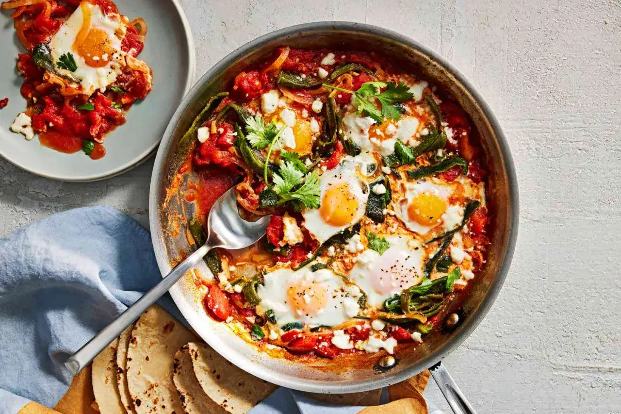 Herzhaftes Gericht mit pochierten Eiern in w&uuml;rziger Tomatensauce, garniert mit Koriander und Feta. Dazu passen Tortillas.