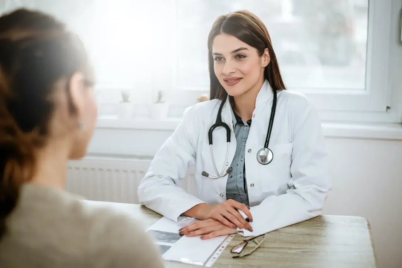 Medico sorridente ascolta paziente, cercando di alleviare la sua paura dei medici.