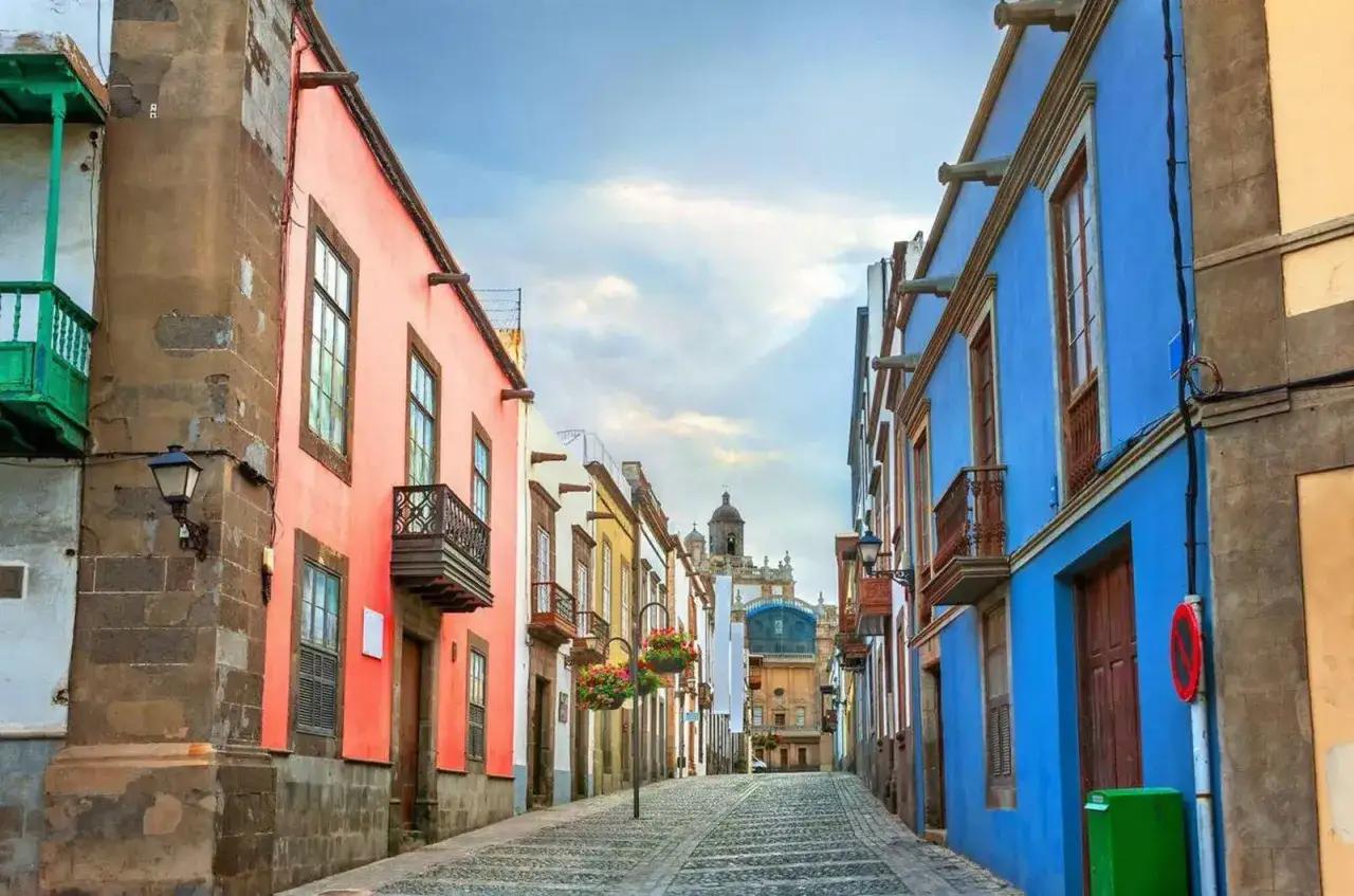 Calle empedrada con casas de colores vibrantes, ideal para tu plan de qu&eacute; ver en Las Palmas de Gran Canaria en 7 d&iacute;as.