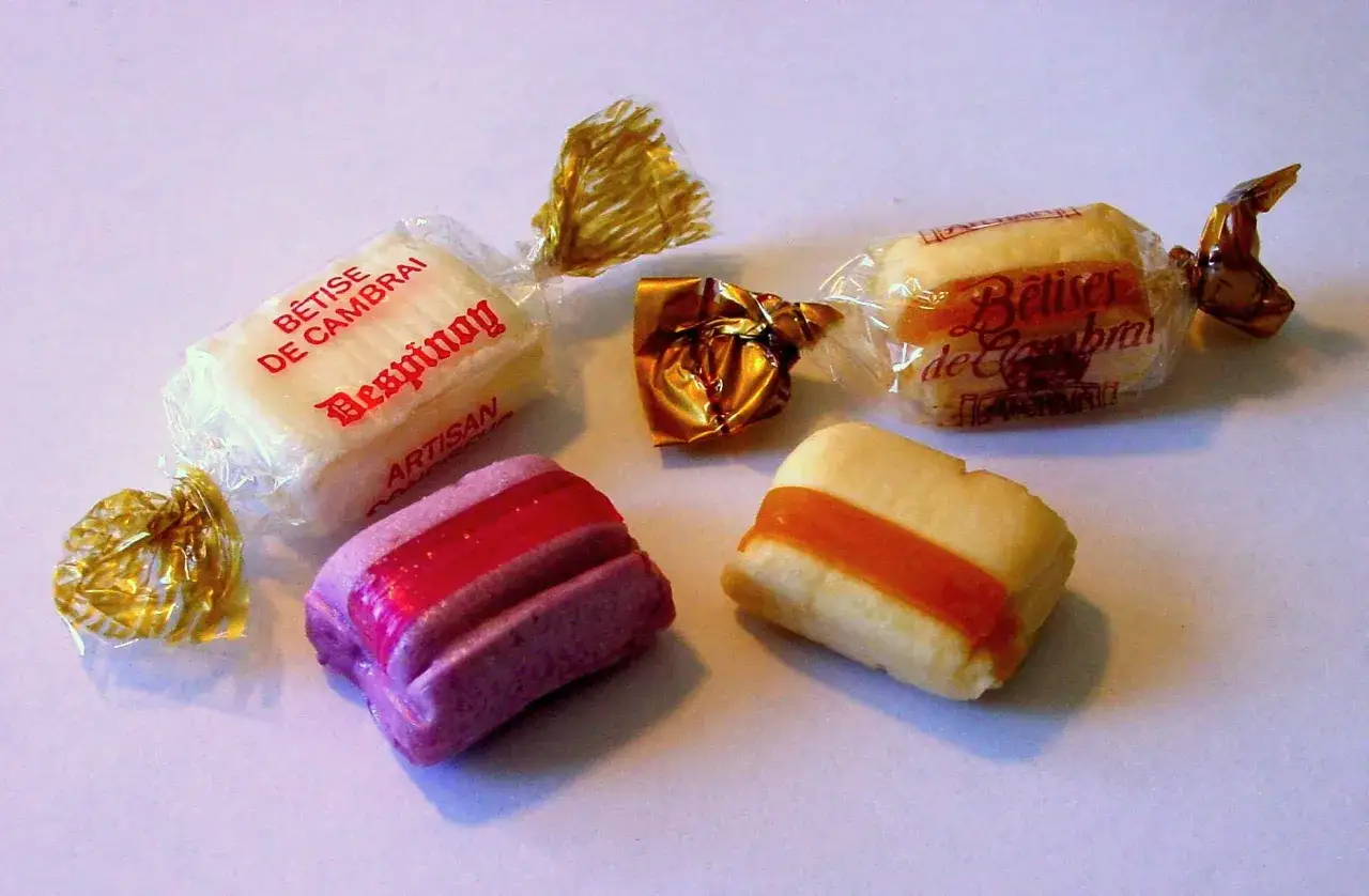 Dulces artesanales Betises de Cambrai, algunos envueltos en celofán dorado, otros con franjas de colores.