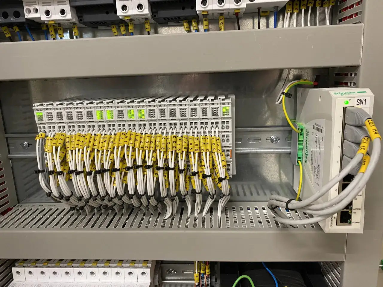 Panel sterowania z licznymi przewodami i modułami, gotowy do automatyzacji procesów.