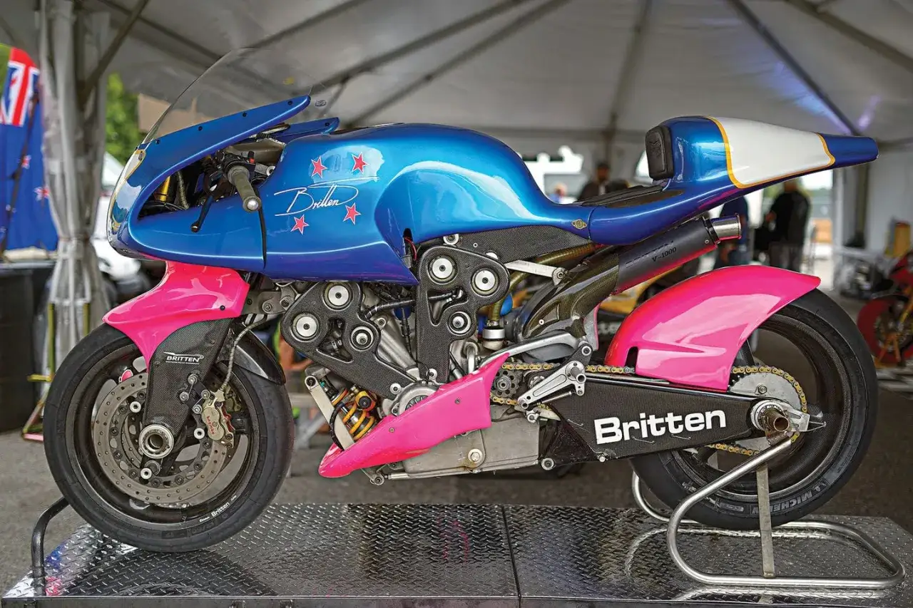 La Britten V1000, una moto de carreras azul y rosa con estrellas rojas, exhibe su motor V-twin y su dise&ntilde;o aerodin&aacute;mico.