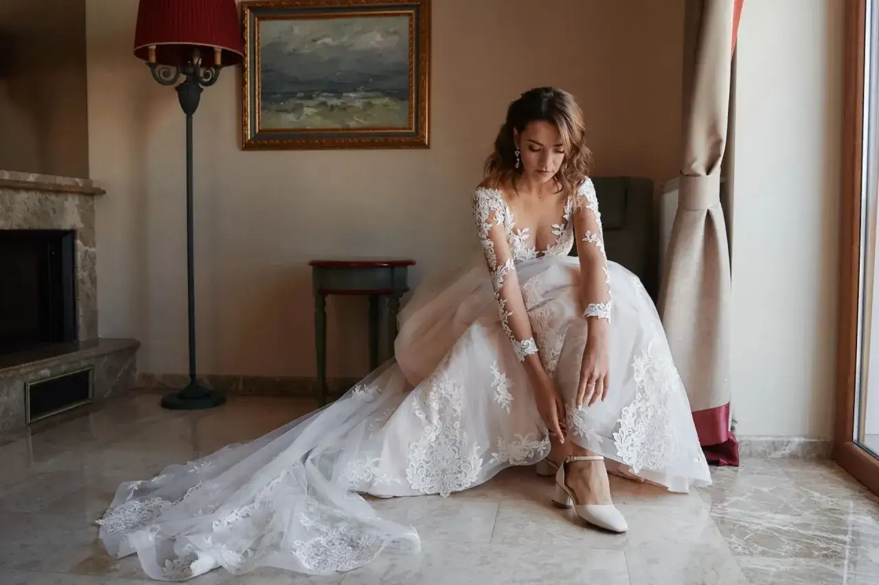 Panna młoda w koronkowej sukni ślubnej i eleganckich butach