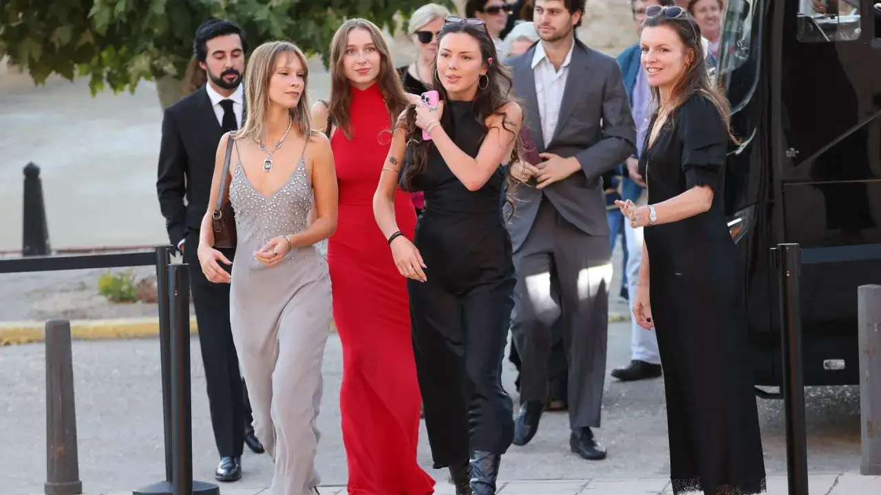 Un grupo de personas elegantes, incluyendo a Stella Banderas, camina hacia un evento.