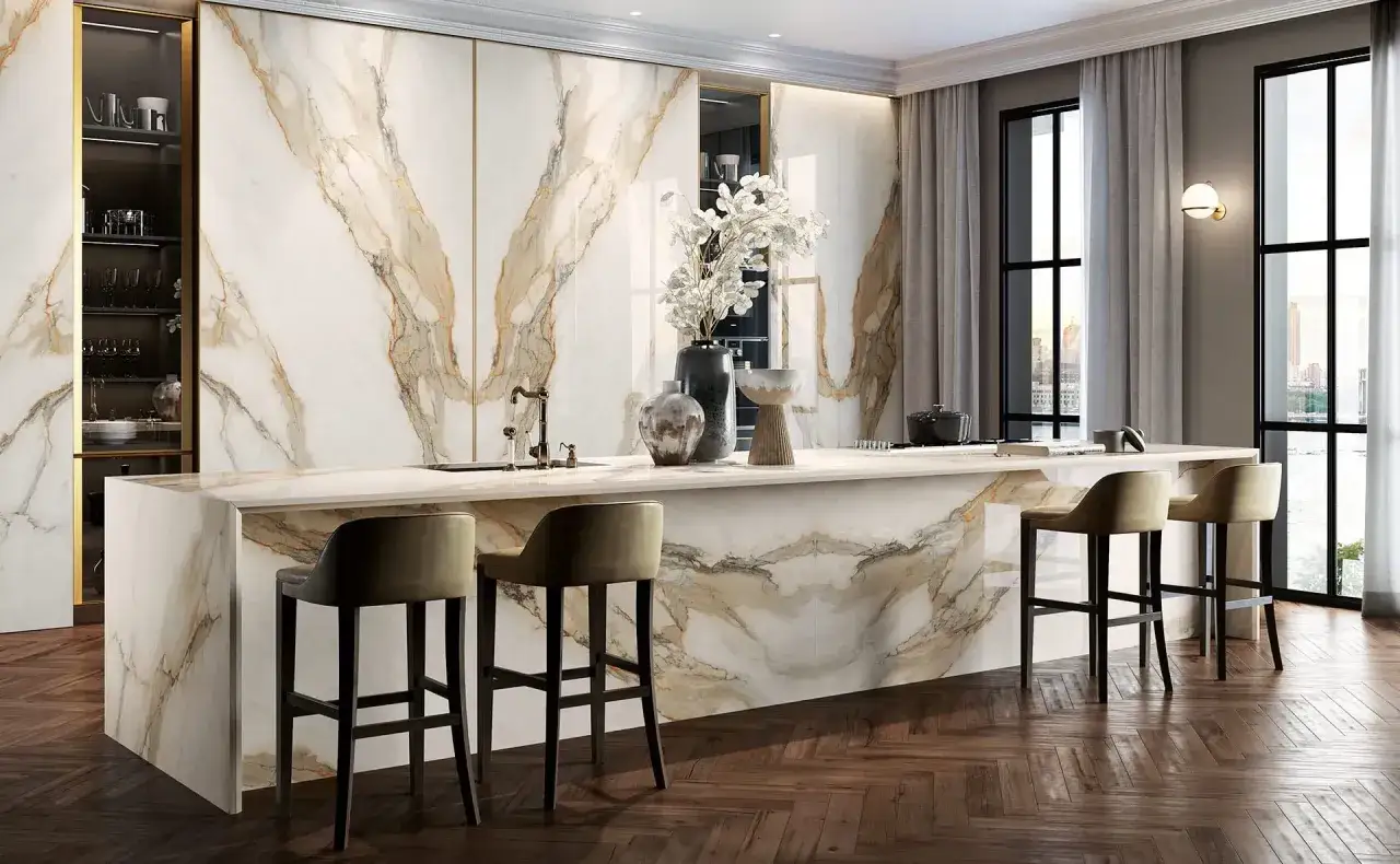 Elegante cucina con isola centrale e rivestimenti in gres effetto marmo. Il parquet a spina di pesce completa la posa pavimento gres.
