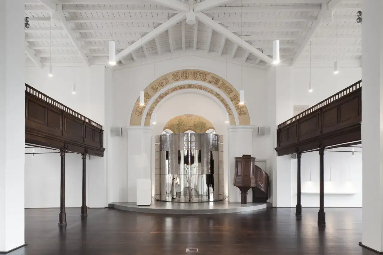 Modernes Interieur einer reformierten Kirche mit Holzbalkonen, einem gl&auml;nzenden Altar und einer Kanzel.