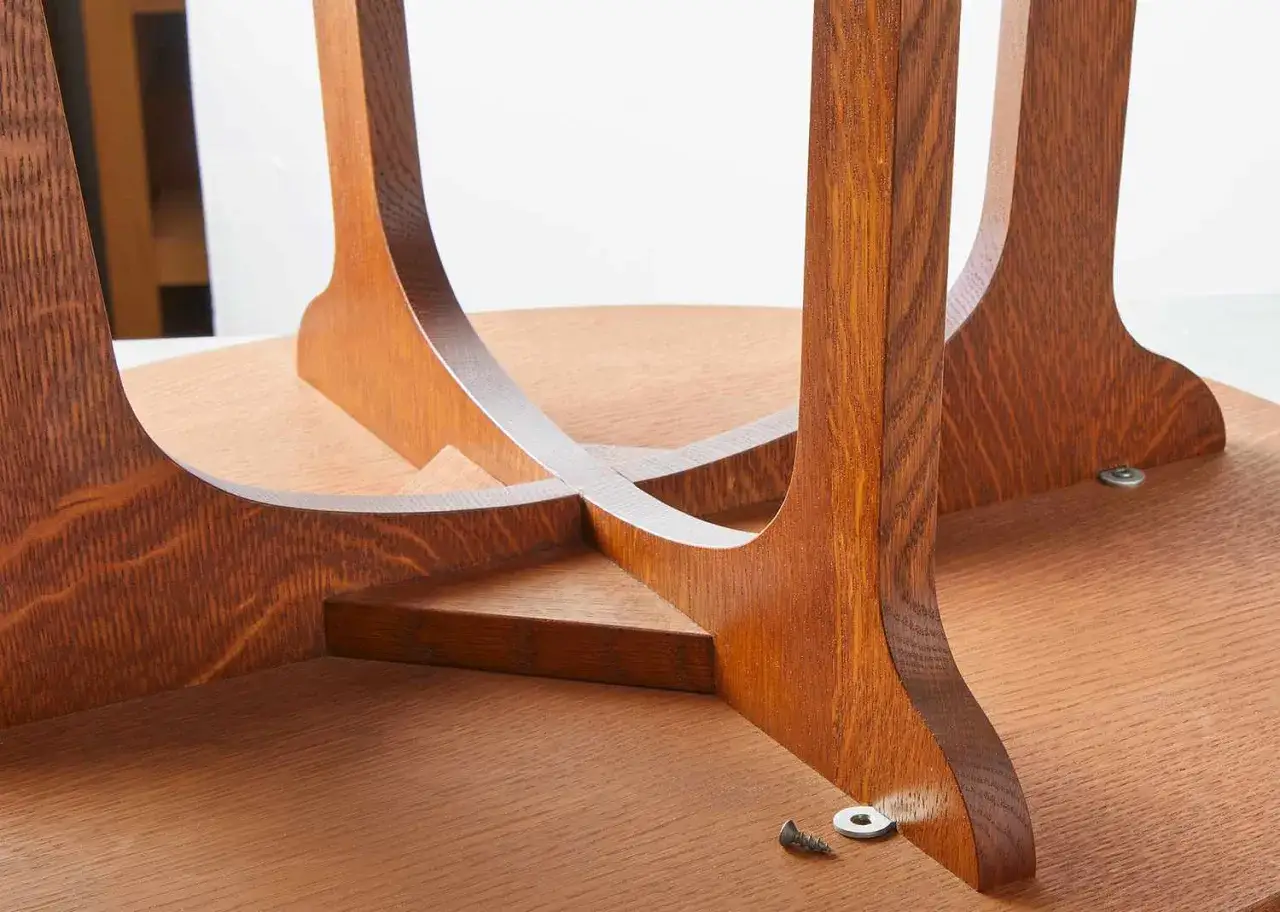 Close-up of the underside of a wooden diy table, showing the curved legs and intersecting supports.