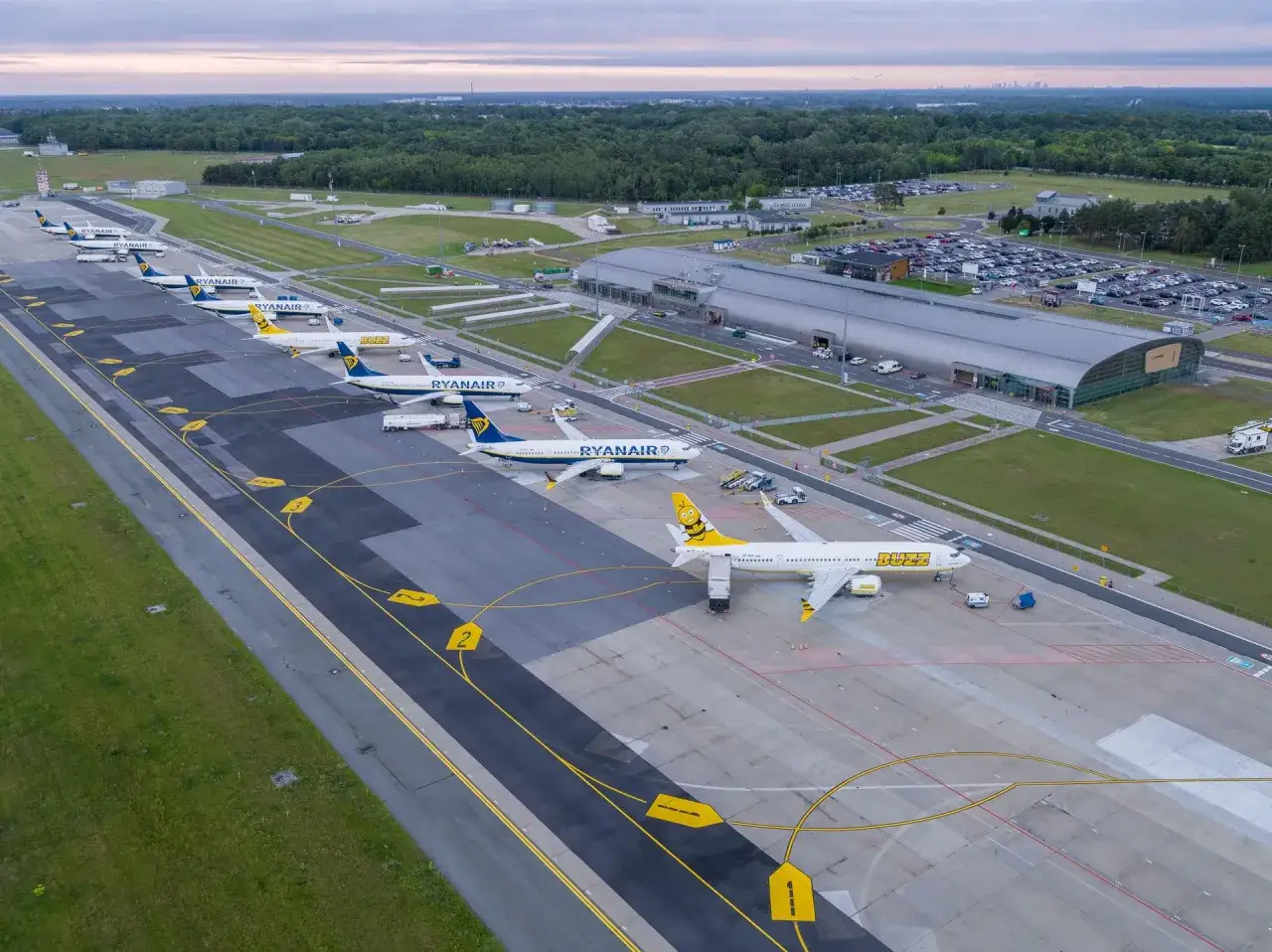 Samoloty Ryanair i Buzz na płycie lotniska. Widać budynek terminala i parking. Czy lotnisko w Modlinie jest czynne? Tak, wygląda na to, że tak!