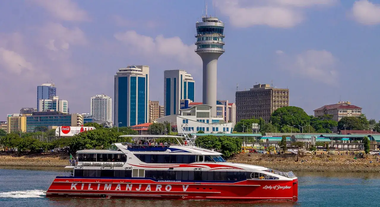 Widok na nowoczesne budynki i wieżę kontrolną w Dar es Salaam, z czerwoną łodzią 