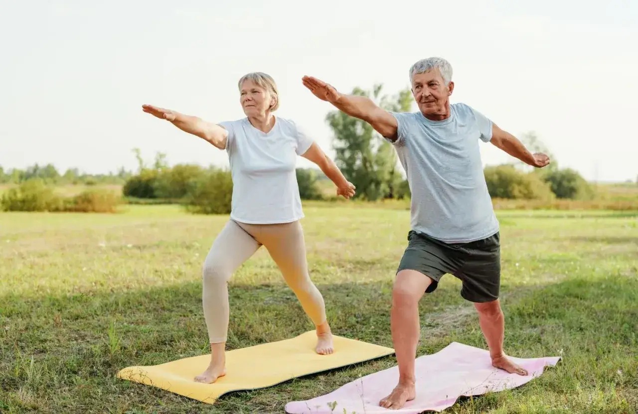 Couple &acirc;g&eacute; pratiquant le yoga en plein air, un moment de bien-&ecirc;tre mental et physique dans la nature.