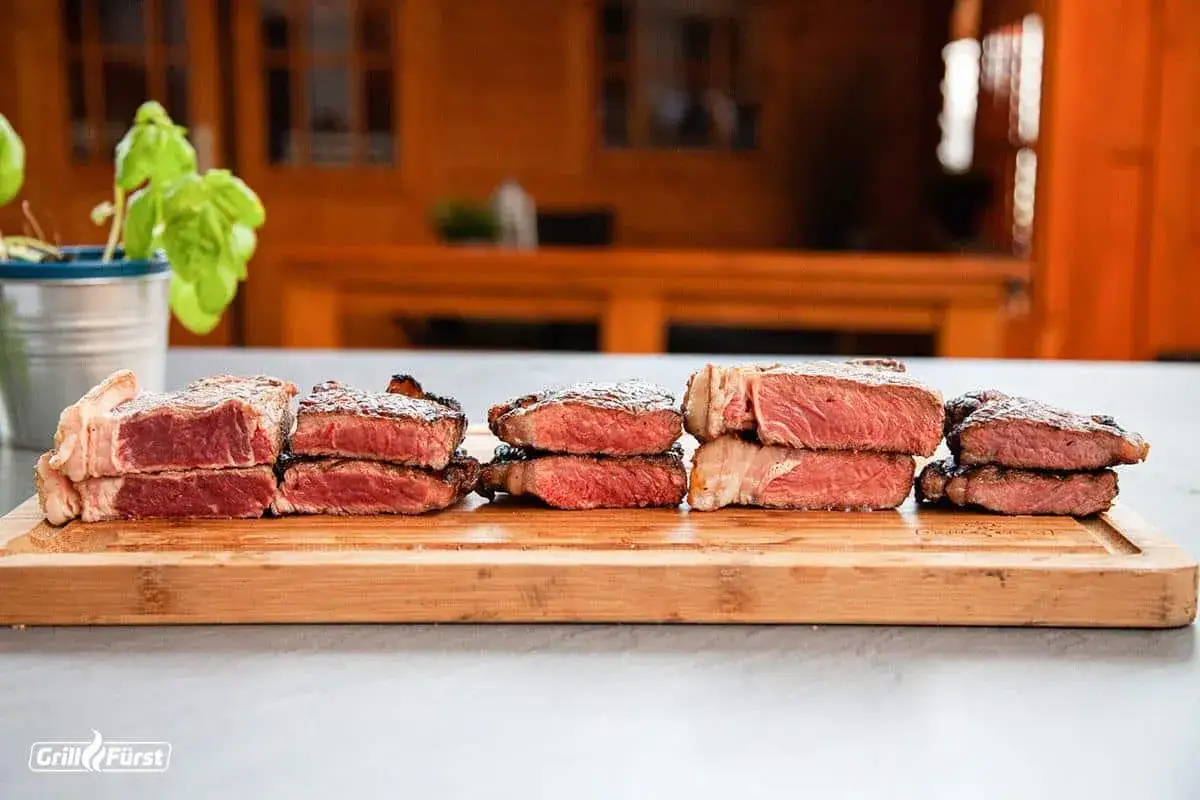 Sechs gestapelte Steaks zeigen verschiedene steak garstufen, von blutig bis medium.