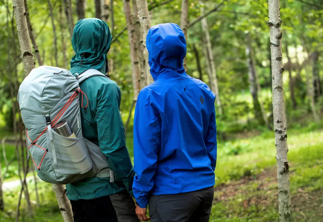 Tv&aring; personer med ryggs&auml;ckar i skogen, kl&auml;dda i jackor med gore tex membran som skyddar mot v&auml;der och vind.