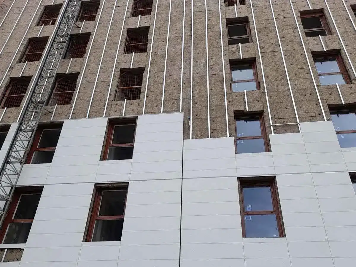 Fachadas rehabilitadas en proceso de construcción, con aislamiento visible y ventanas de madera.